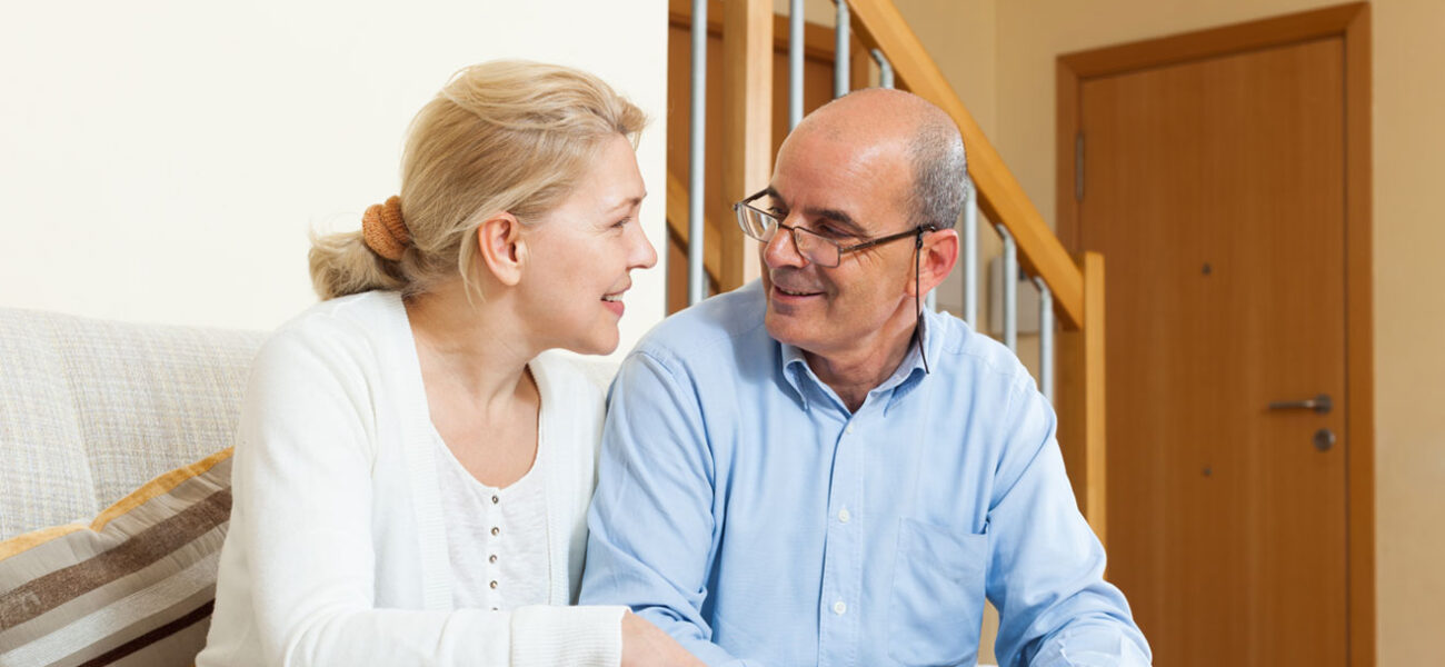 A woman and a man sitting on a couch to try the onboard process for Medicare Shepherd.