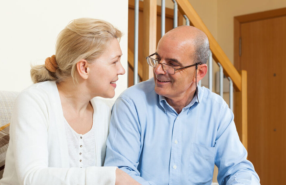 A woman and a man sitting on a couch to try the onboard process for Medicare Shepherd.